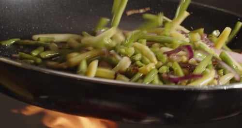 Over High Heat Fry Green Asparagus With Sausage In A Pan