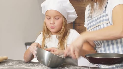 Child and Adult Baking Together in Kitchen