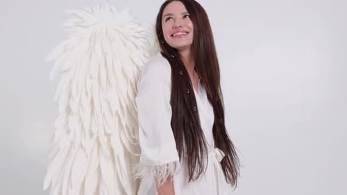 Fille au ralenti avec des ailes d'ange sur fond blanc