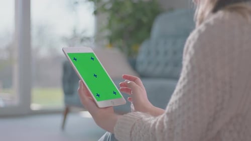 Person Using Tablet with Green Screen Indoors