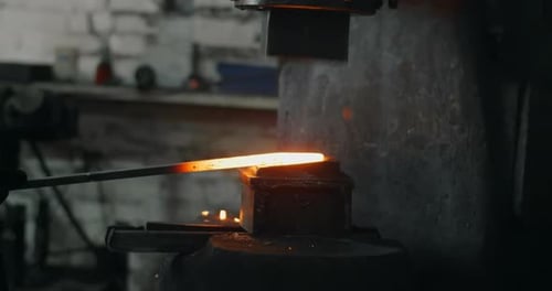 Blacksmith Uses a Hydraulic Hammer to Forge Hot Metal in His Workshop Automatic Hammer is Shaping