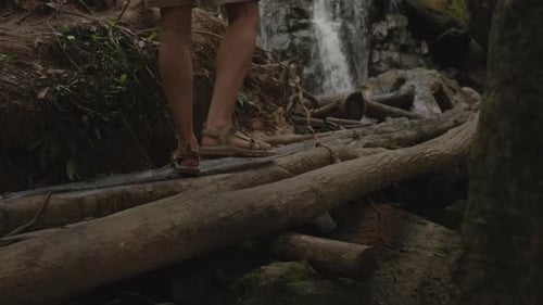 Traveler Looking at Waterfall in Jungle