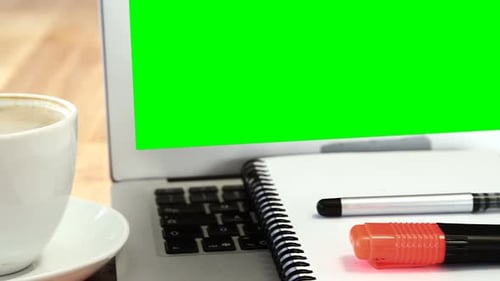 Laptop with Green Screen on Desk With Coffee