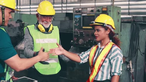 Gruppe von Fabrikarbeitern, die Maschinenausrüstung in der Fabrikwerkstatt verwenden