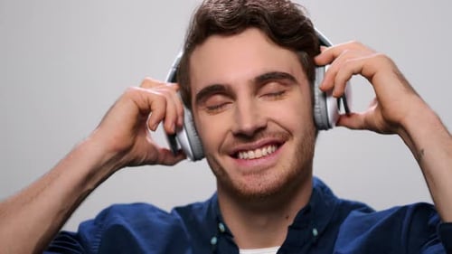 Young Man Enjoys Music with Headphones Indoors