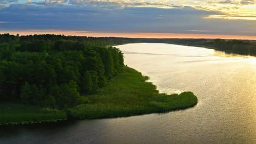 Aerial view of lonely boat on lake in summer at sunset