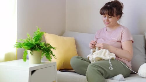 Woman Knitting on Couch in Cozy Home