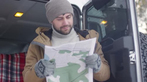 Tourist with Map in Forest