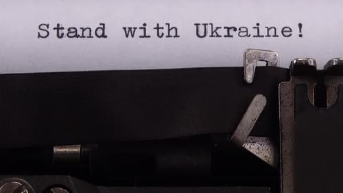 Typing phrase "Stand with Ukraine !" on retro typewriter.