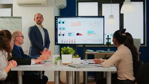 Business Team Receives Presentation in Modern Office