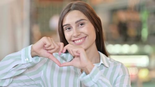 Smiling Woman Making Heart Shape with Hands