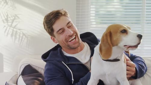 Man Laughing with Beagle Dog at Home