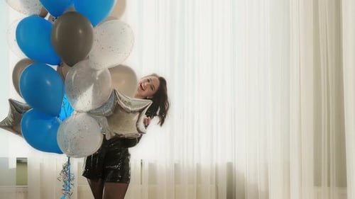 Happy Woman with Balloons Smiles in Celebration