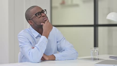 Man at Desk Contemplating in Workplace Setting