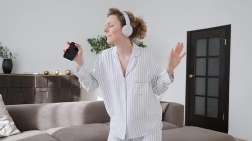 Woman Dancing at Home with Headphones and Phone