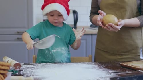 Child Wearing Santa Hat Baking Cookies