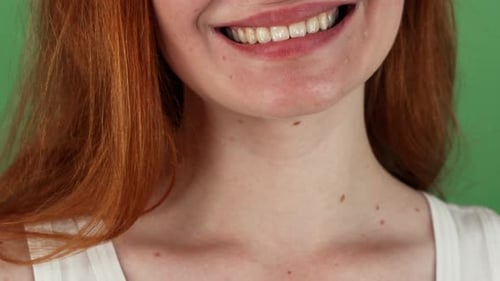 Mujer pelirroja sonriendo alegremente sobre fondo verde Chromakey