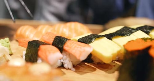 Sushi Platter with Chopsticks Picking Up Sushi
