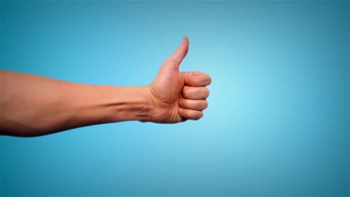 Hand Showing Thumbs Up on Blue Background