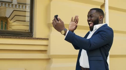 Man in Suit Chatting on Smartphone in City
