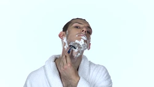Young Man Shaving his Face with Razor