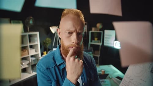 Young Hipster Professional Doubting Near Working Board with Stickers in Office.