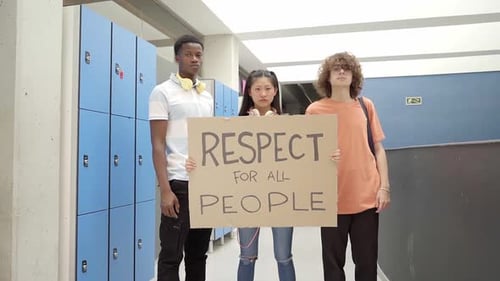 Groupe multiethnique d'étudiants portant une bannière sur laquelle est écrite la phrase « Respect pour tous »