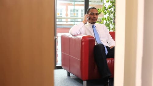 Businesss male talking on mobiel phone in office