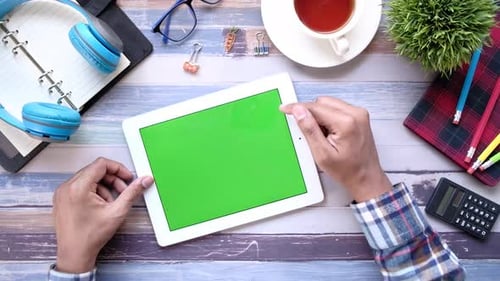 Hands Using Tablet with Green Screen at Desk