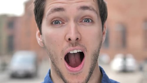 Outdoor Close Up of Positive Wondering Young Man