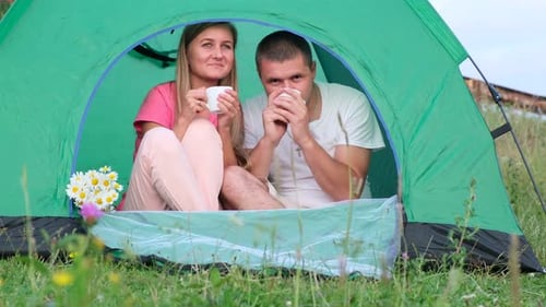 Smiling Couple Relaxing in a Camping Tent