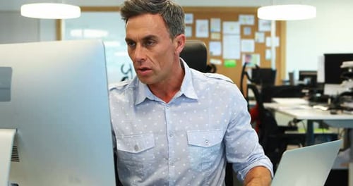 Man Works On Computer In Open Office Environment