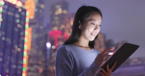 Woman use of digital tablet computer at night