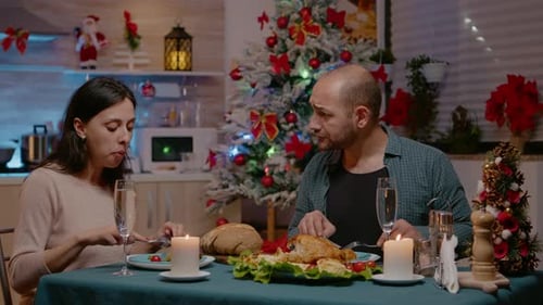 Couple mangeant de la nourriture au dîner de fête et des verres tintant