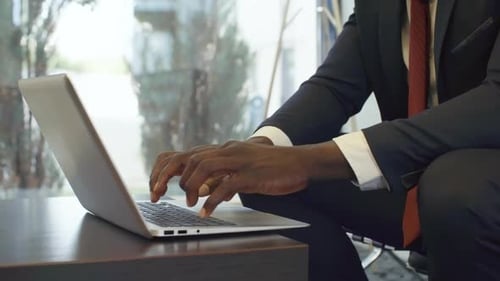 Adult Typing on Laptop in Modern Workspace