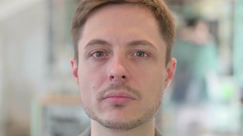 Nahaufnahme des Gesichts eines jungen Mannes, der in die Kamera schaut