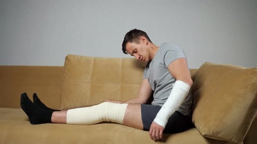 Man with Cast and Bandage Resting on Couch