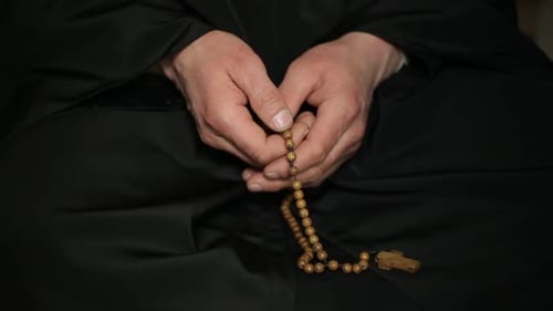 Adult Hands Moving Rosary Beads