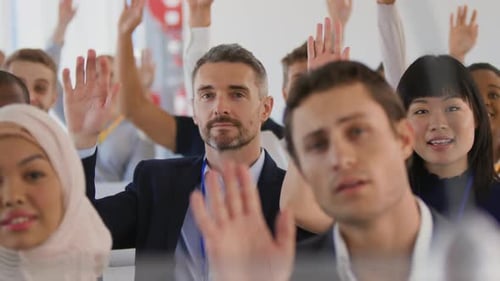Diverse Group Raises Hands in Corporate Meeting