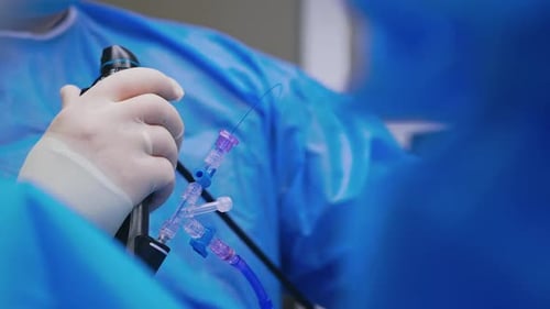 Surgical Procedure with Gloved Hand Holding Medical Device