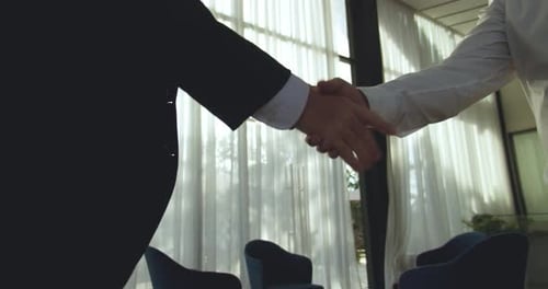 Firm Handshake Inside a Corporate Office Building