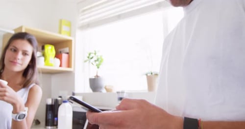 Couple in Kitchen Uses Smart Phone