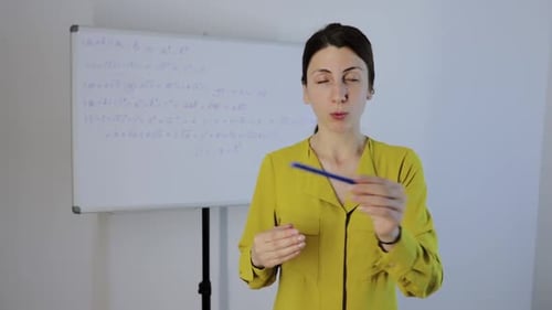 Teacher Explaining Math Equations on Whiteboard
