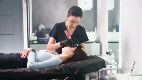 Woman Performing Permanent Makeup Procedure in Clinic