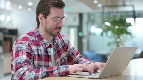 Young Adult Working on Laptop in Office