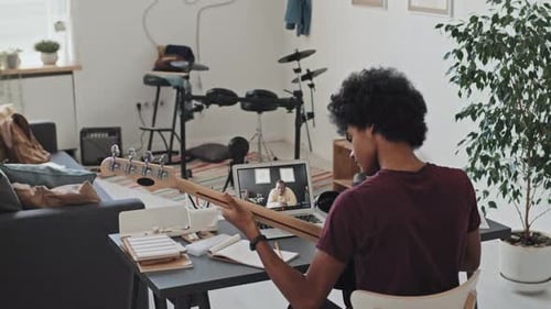 Teen Playing Guitar During Online Lesson