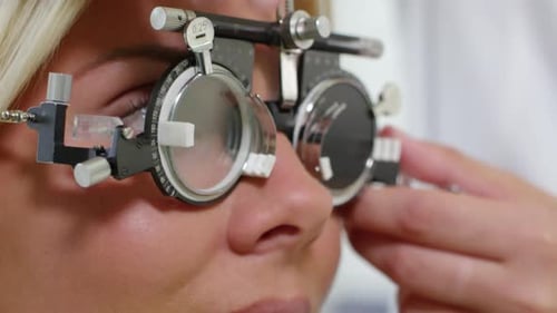 Fröhliche Frau überprüft das Sehen beim Optiker