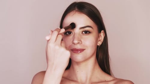 Young Woman Applying Makeup with Brush