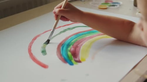Child Painting a Colorful Rainbow with Watercolors