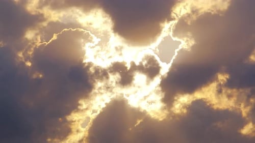 Golden Sunlight Pierces Dark Clouds in Dramatic Sky